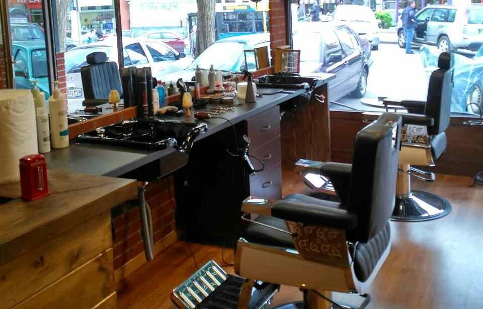 Ο χώρος του Andrew’s Barber House: ο πάγκος με τα προϊόντα, οι δύο δερμάτινες καρέκλες και το ξύλινο πάτωμα